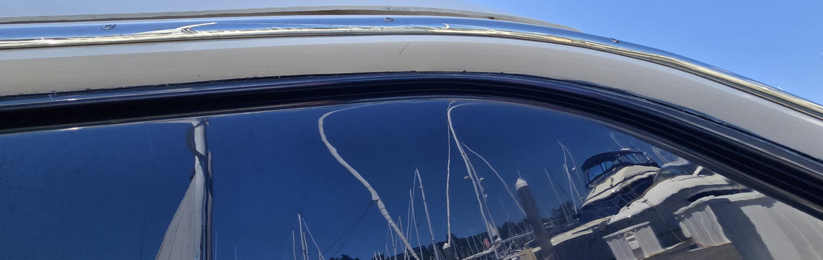 A Seattle marina reflected in the polished window of a motor yacht