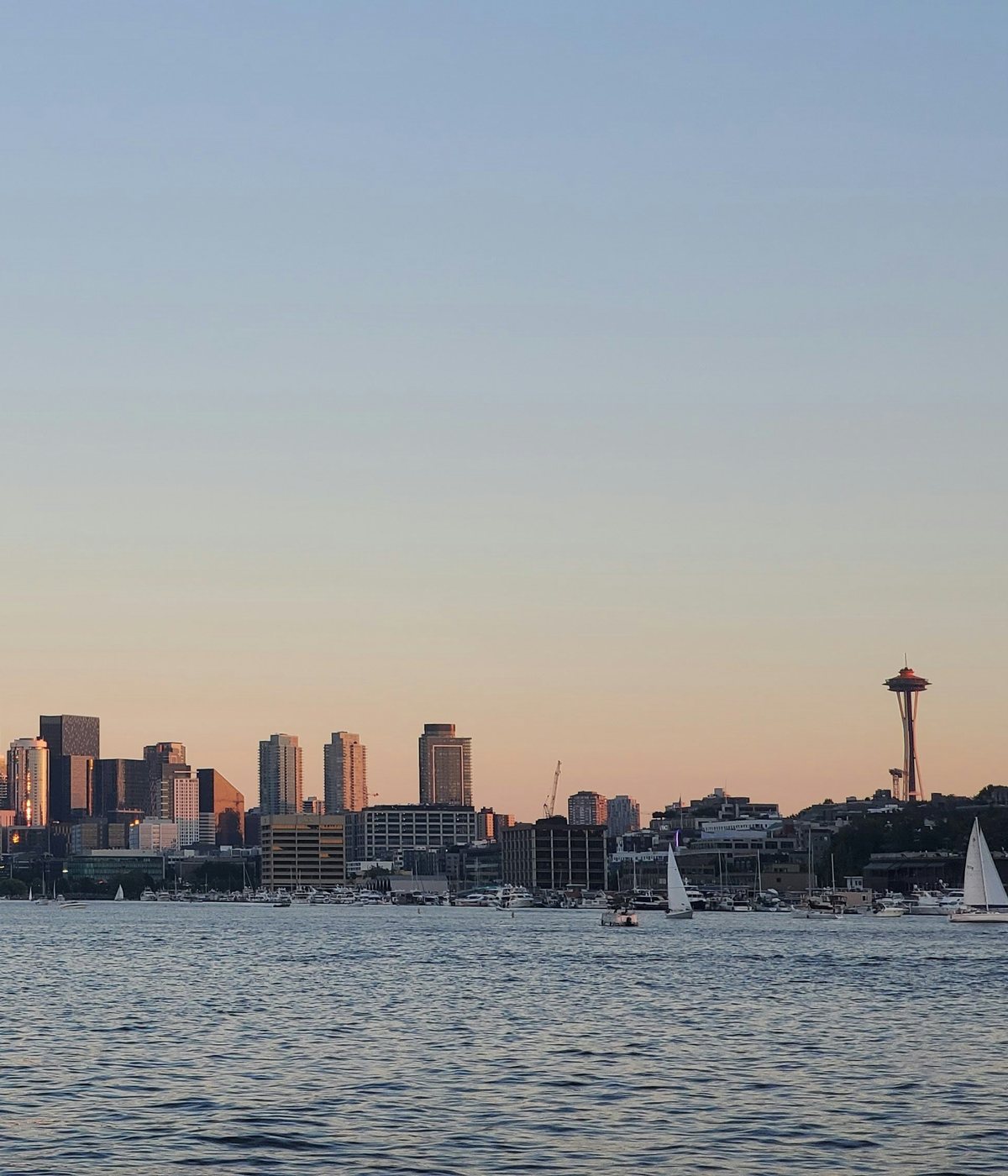 Downtown Seattle and the Space Needle at sunset across Lake Union, with boats on the water